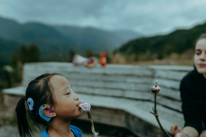 Image of two girls eating toasted marshmallows on a stick