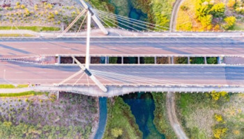 Aerial photo of a concrete bridge over a track and a river