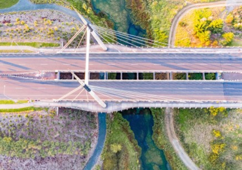 Aerial photo of a concrete bridge over a track and a river